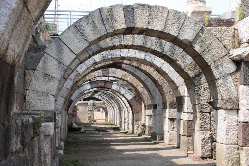 a stone tunnel with a clock tower in the background