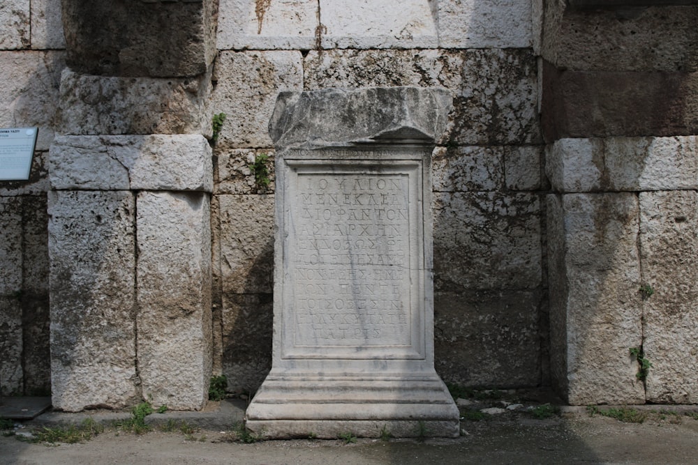 Un monumento de piedra frente a un muro de piedra