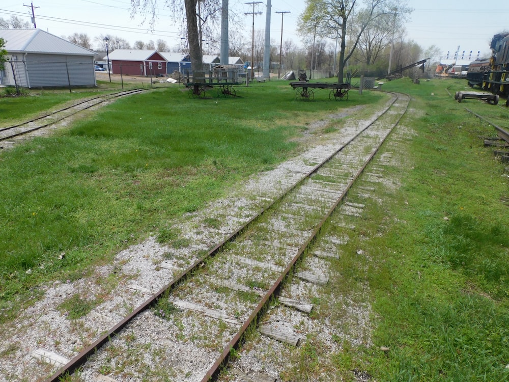 a grassy area with railroad tracks in the foreground
