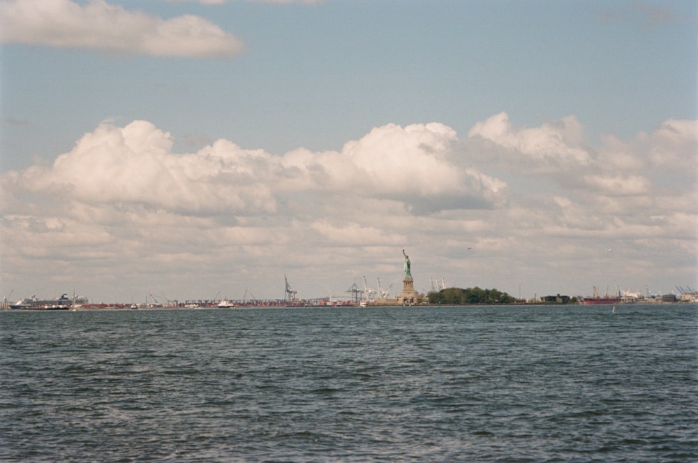 a large body of water with a statue of liberty in the background