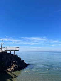Photo of a calm coastal monitoring station with sensors against a clear sky.