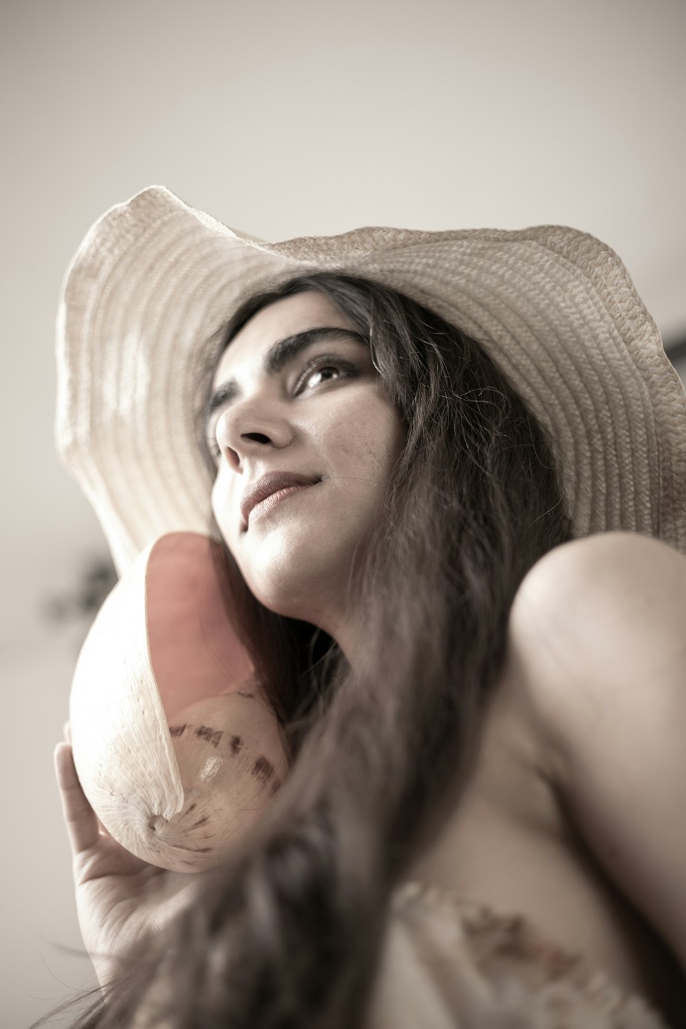 a woman with a hat holding a banana
