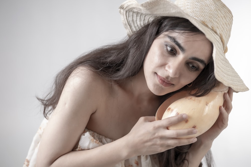 a woman in a hat holding a piece of bread