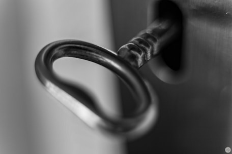 Close-up of a locksmith cutting a key with precision tools.