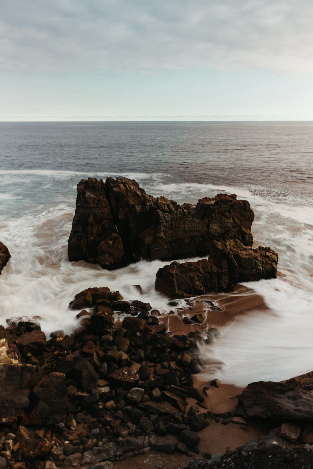 a large body of water next to a rocky shore