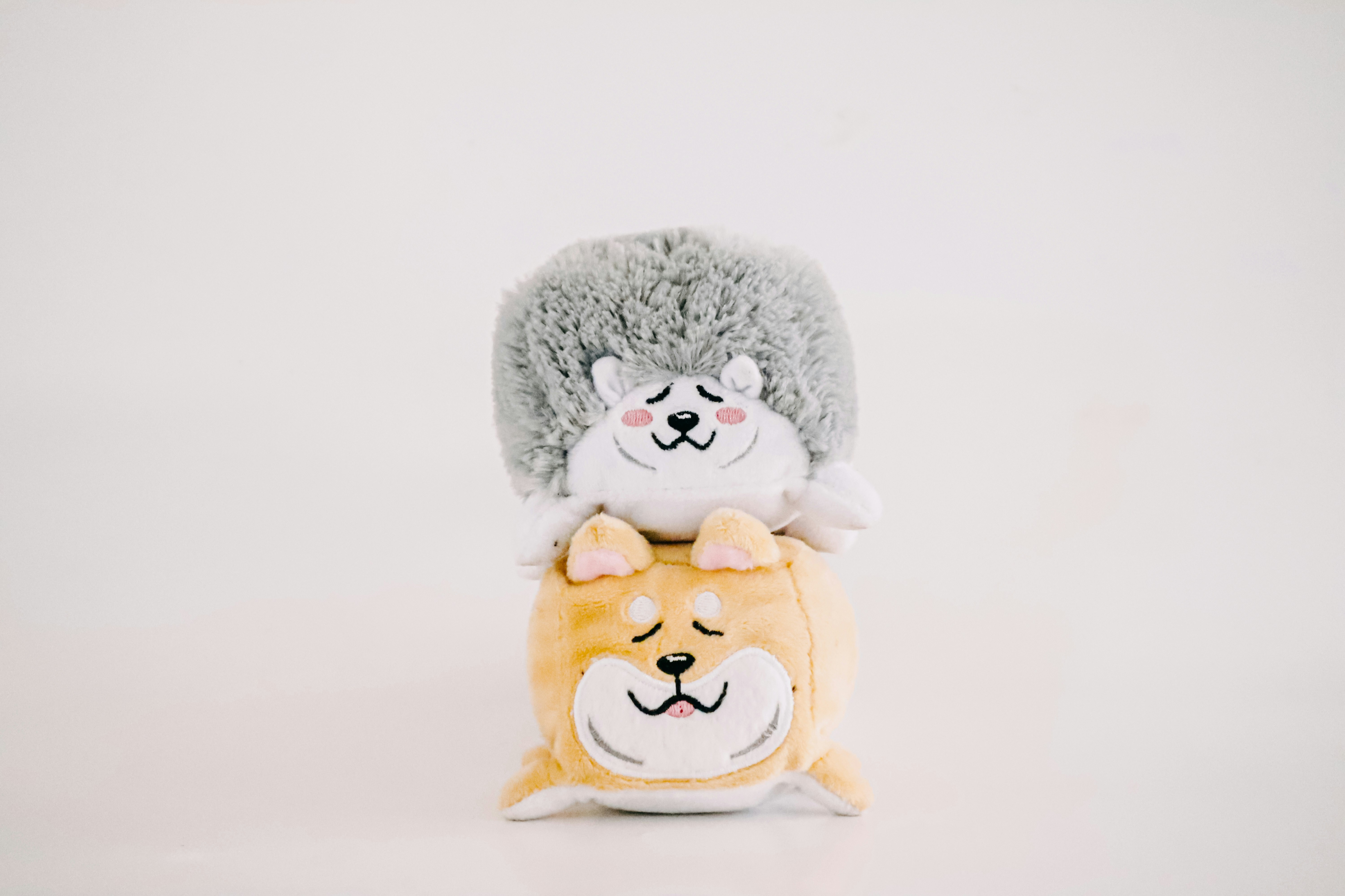 two stuffed animals sitting on top of each other