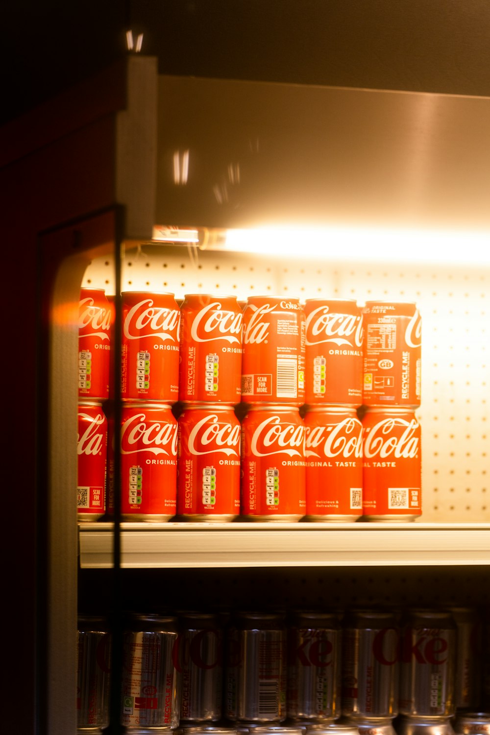 a shelf filled with cans of coca cola
