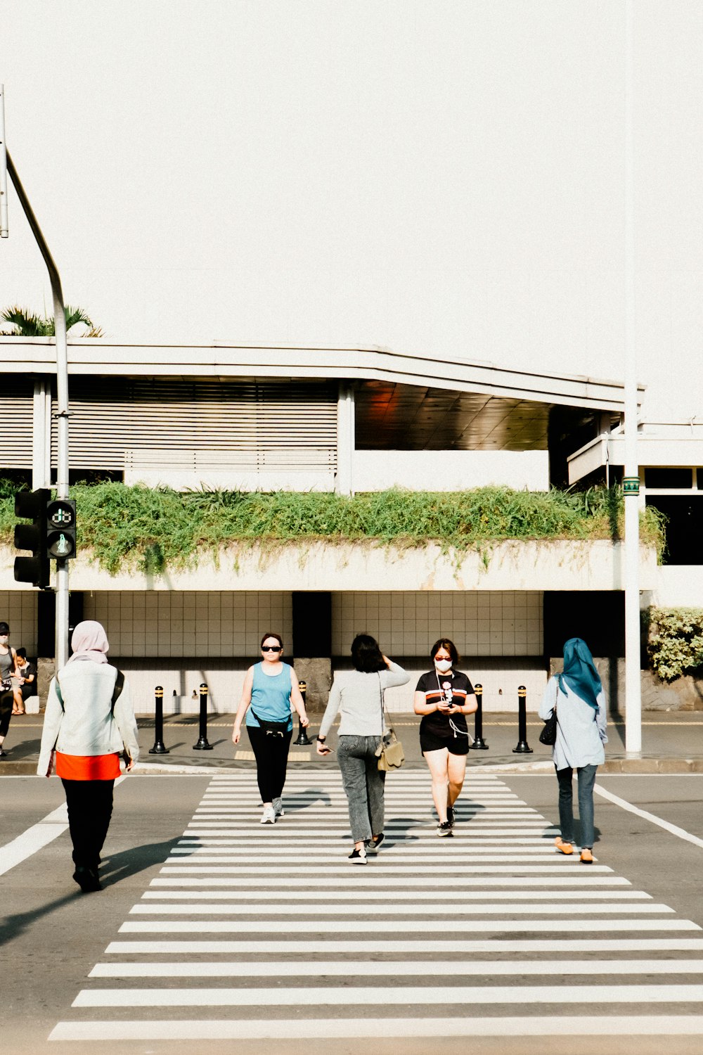 a group of people walking across a cross walk