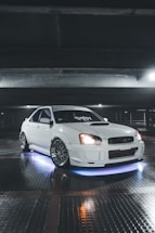 A sleek customized car parked in a modern garage with warm lighting