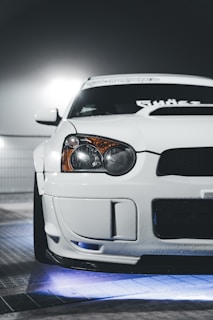 A vibrant LED underglow illuminating a sleek car at night.