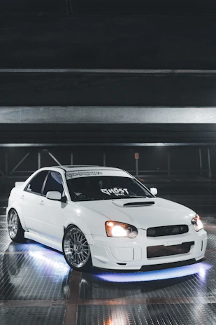 Side skirts and fender flares on a widebody Dodge Charger parked on a dimly lit street.