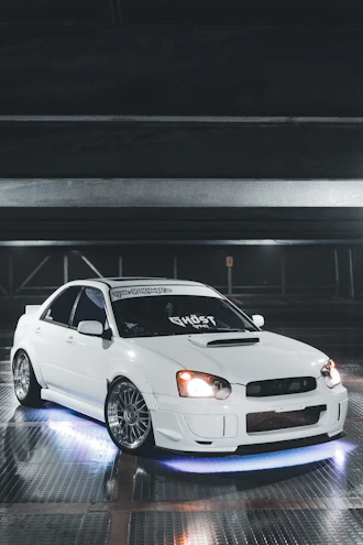 Side skirts and fender flares on a widebody Dodge Charger parked on a dimly lit street.