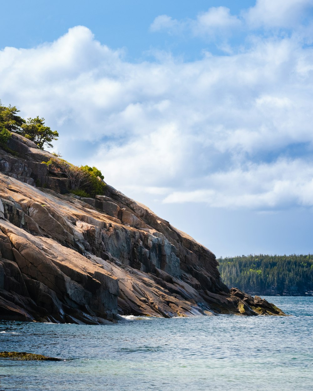 a large body of water sitting next to a rocky cliff