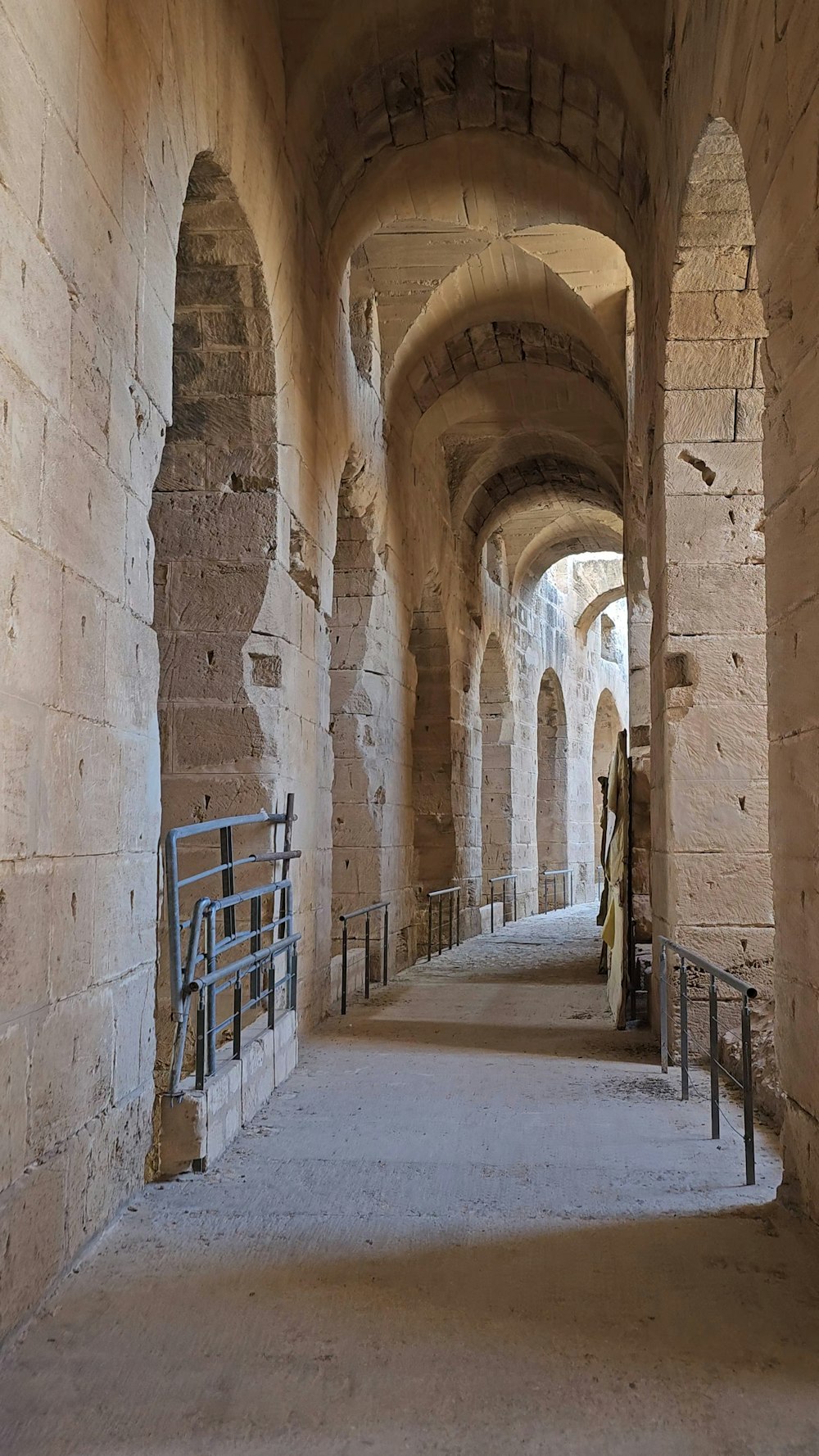 a long hallway with stone walls and arched doorways