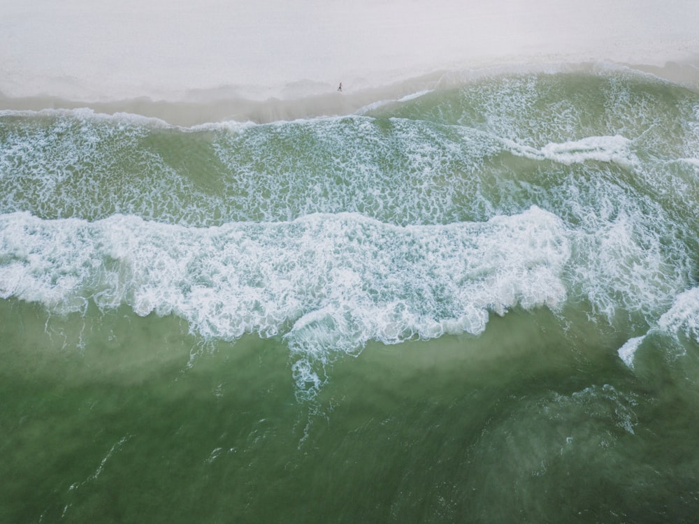 an aerial view of the ocean with waves