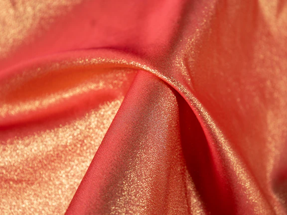 Close-up of rich, glossy Bhagalpuri silk fabric in deep maroon with intricate gold zari work.