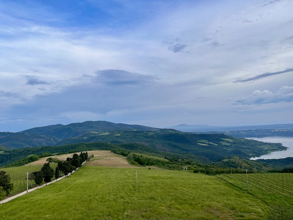 a grassy field with a lake in the distance