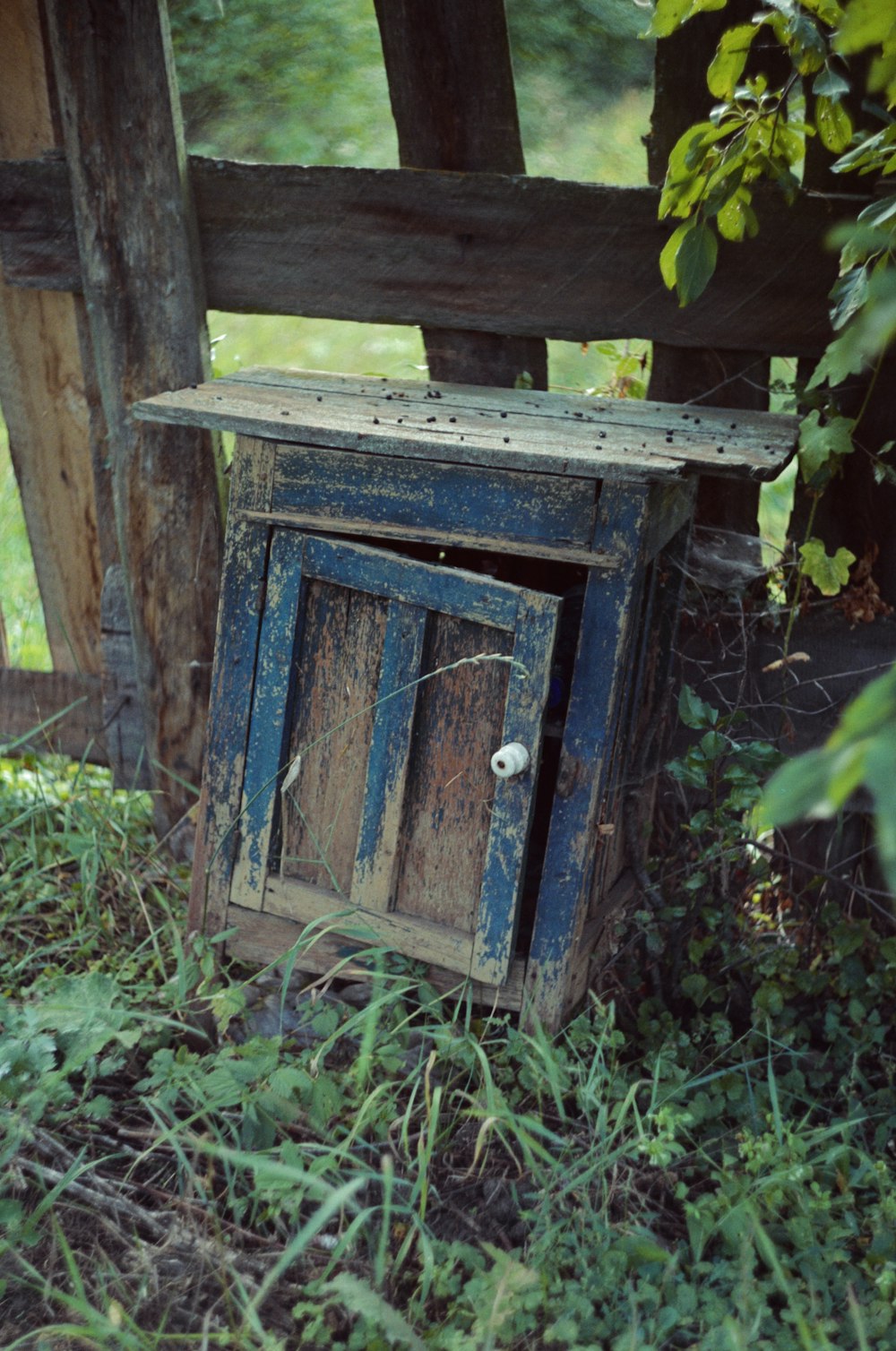 an old wooden cabinet sitting in the grass