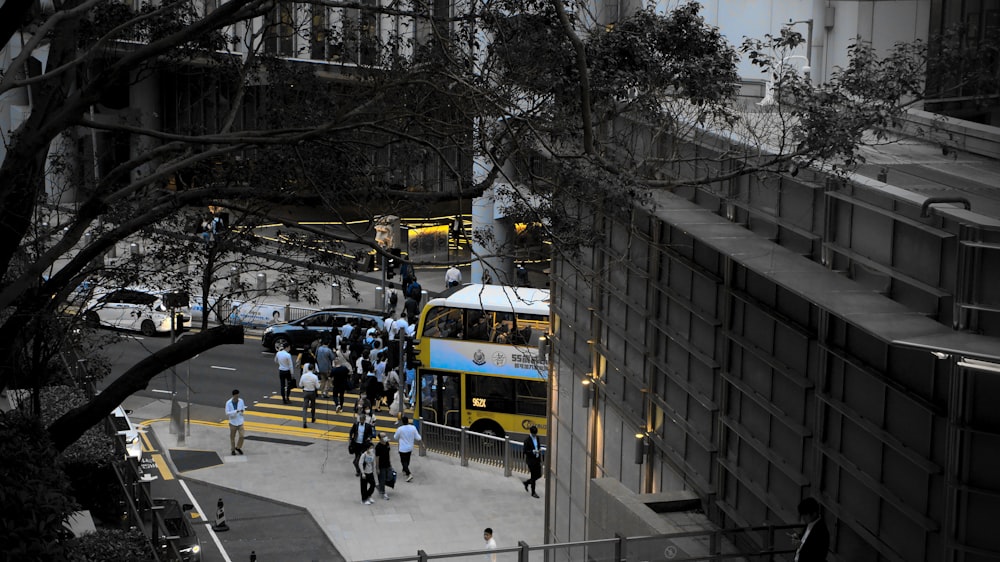 a group of people walking down a sidewalk next to a bus