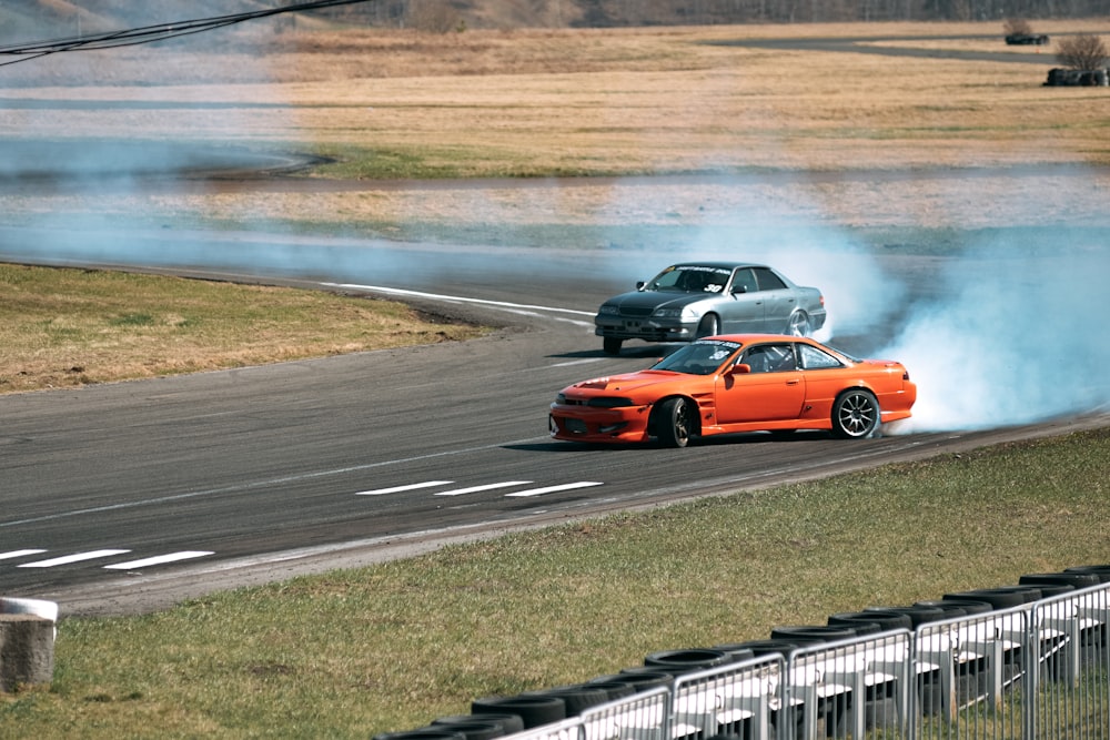 two cars driving on a track with smoke coming out of them