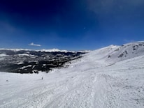 A scenic mountain landscape with skiers enjoying fresh powder snow.