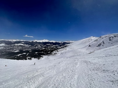 Adventurous tourists skiing down the snowy slopes of Gulmarg under a clear blue sky.