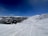 A scenic mountain backdrop with skiers enjoying fresh powder.