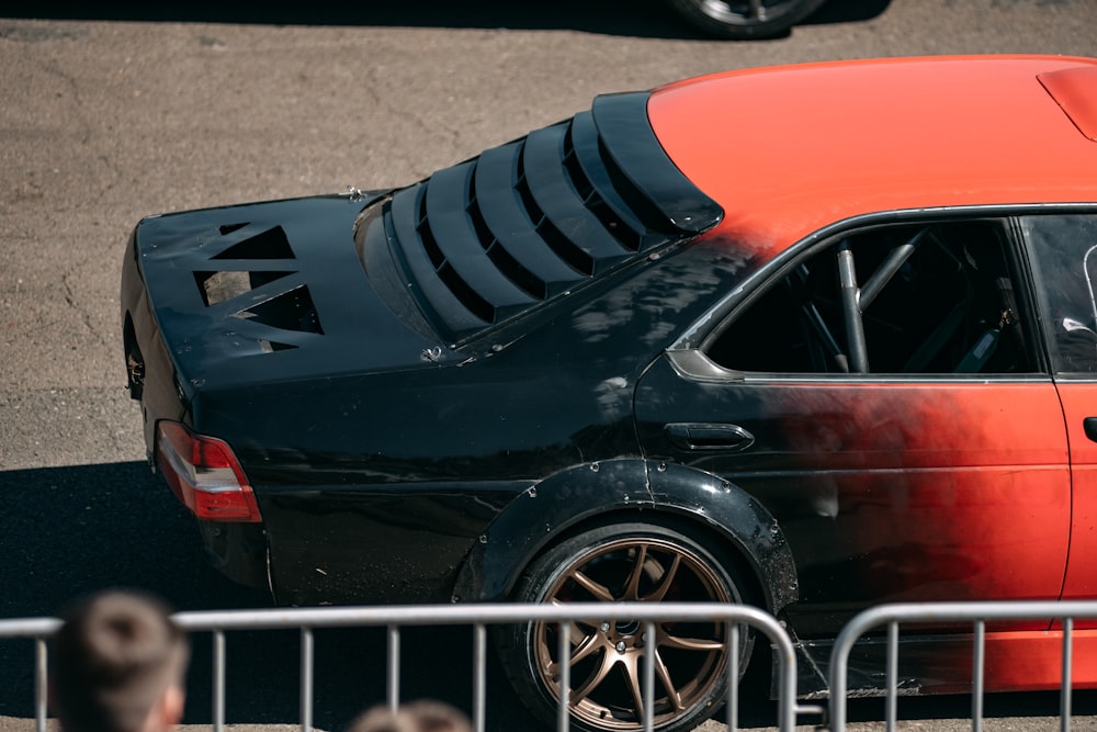 an orange and black car parked in a parking lot