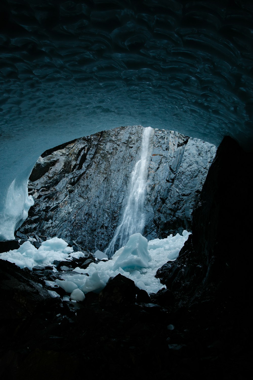 a large ice cave with a waterfall coming out of it