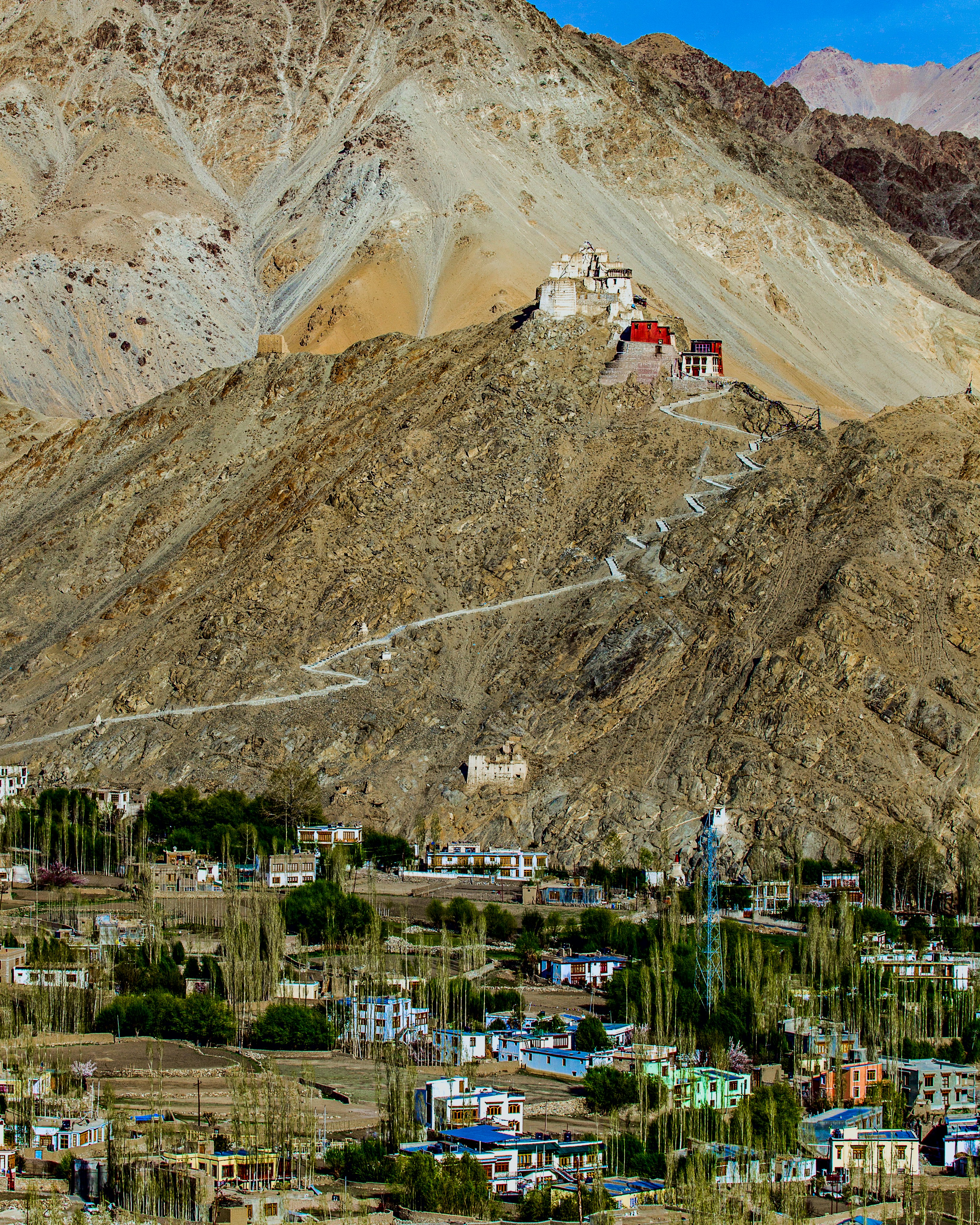 a small town on a hill with a mountain in the background