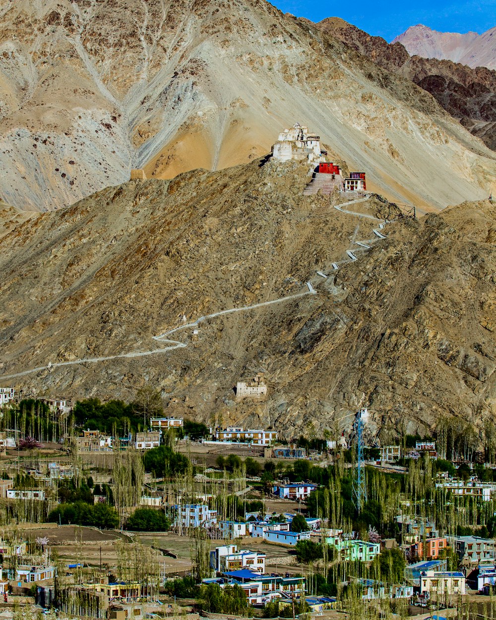 a small town on a hill with a mountain in the background