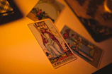 Close-up of the King of Wands tarot card showing his confident gaze and fiery staff.