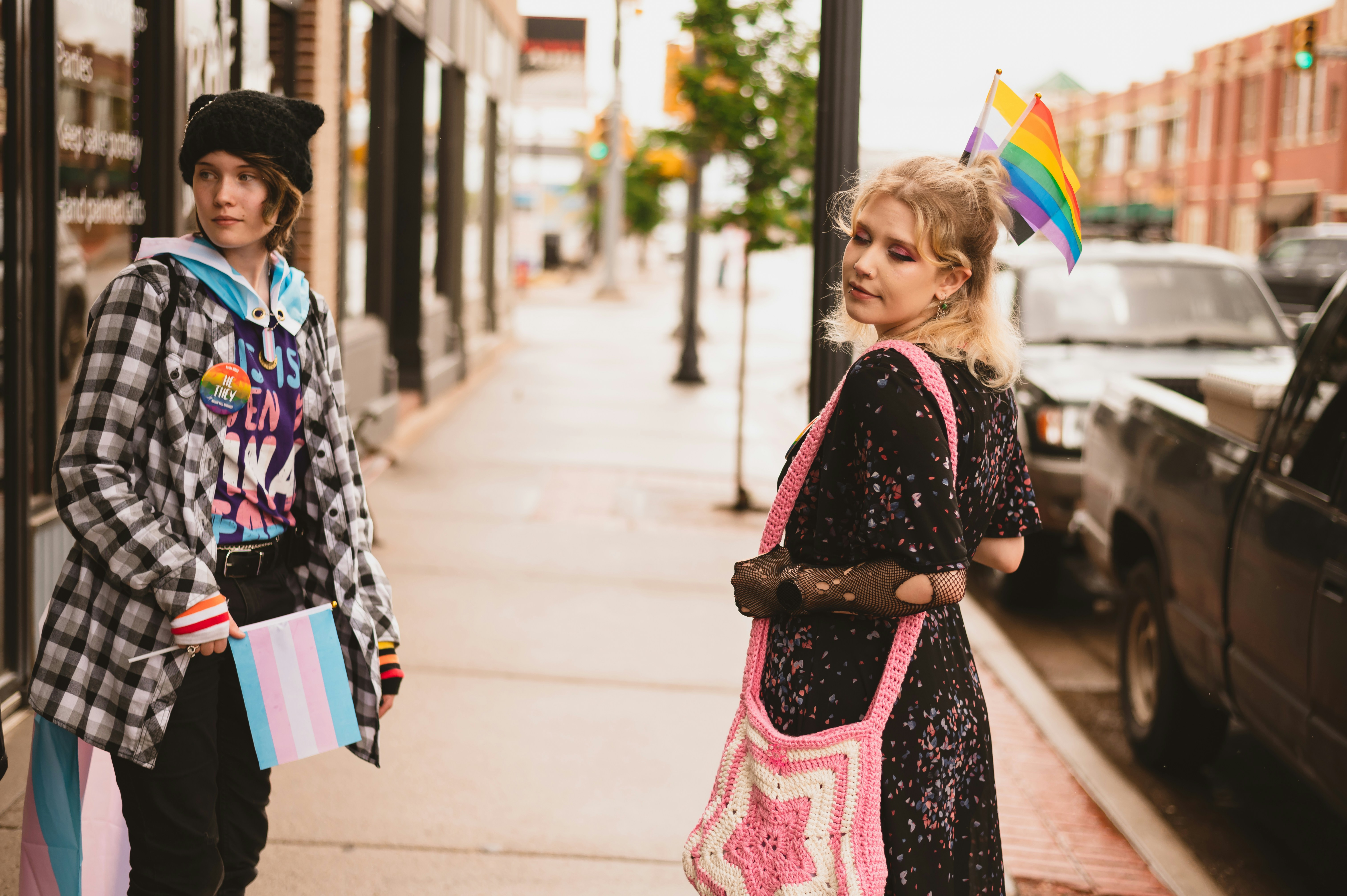 a couple of women standing next to each other on a sidewalk