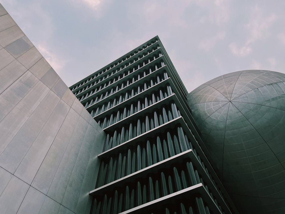 a tall building next to a large round building