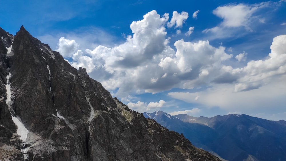 a very tall mountain with some clouds in the sky