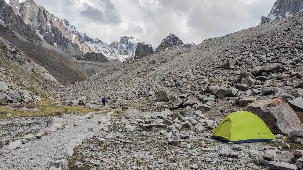 a tent pitched up on the side of a rocky mountain