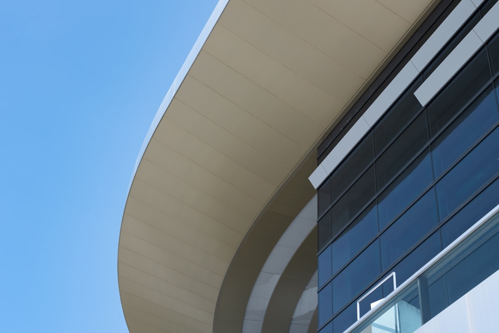 a building with a curved roof and a blue sky in the background