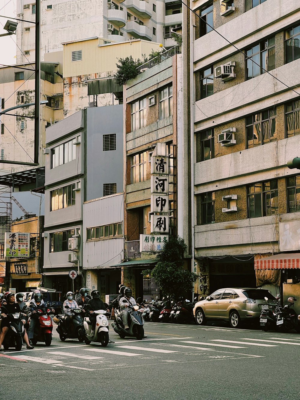 한 무리의 사람들이 스쿠터를 타고 거리를 달리고 있다