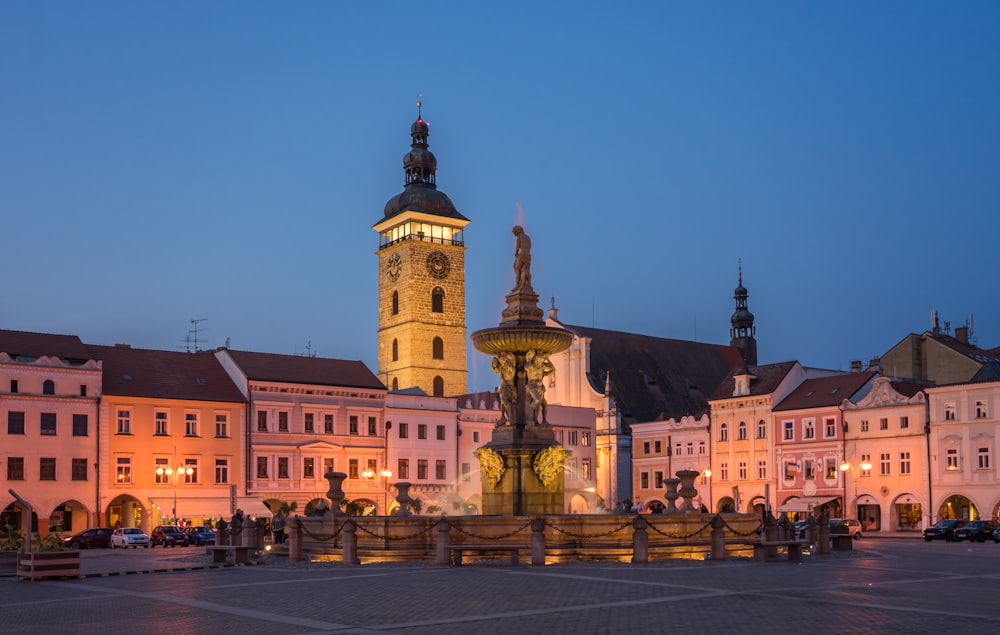a large building with a clock tower next to a fountain