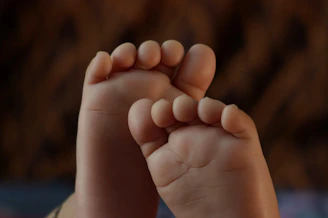 Close-up of a baby's foot in a playful pose, showing the flexible sole of Hoko shoes.