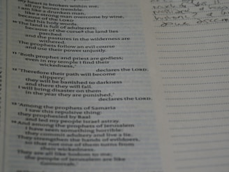 A notebook with handwritten business systems and a Bible open beside it.