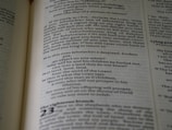 A close-up view of a page from a book with printed text. The text is formatted in paragraphs with clear headings. The page has a cream background and black serif font.