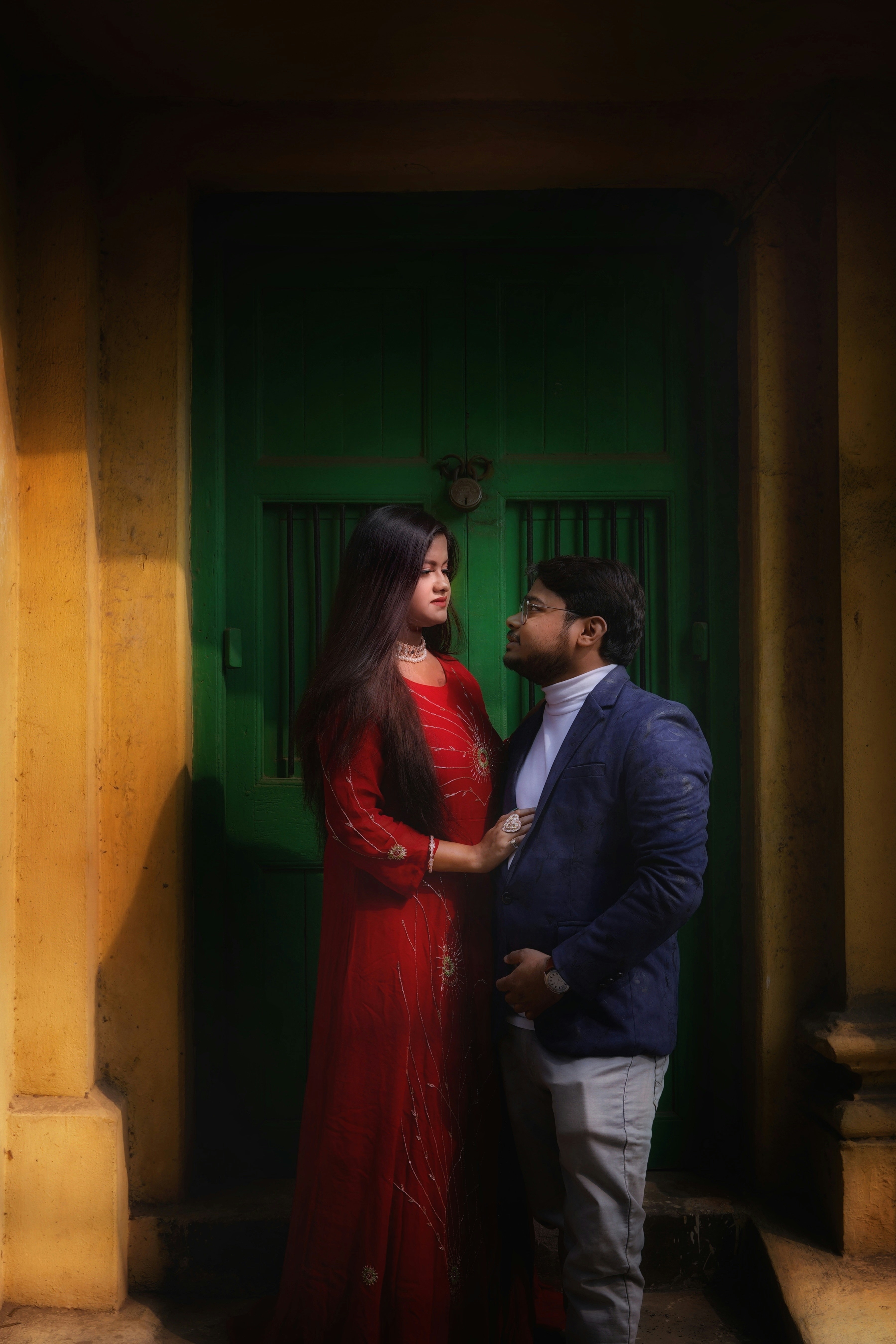 a man and a woman standing in front of a green door