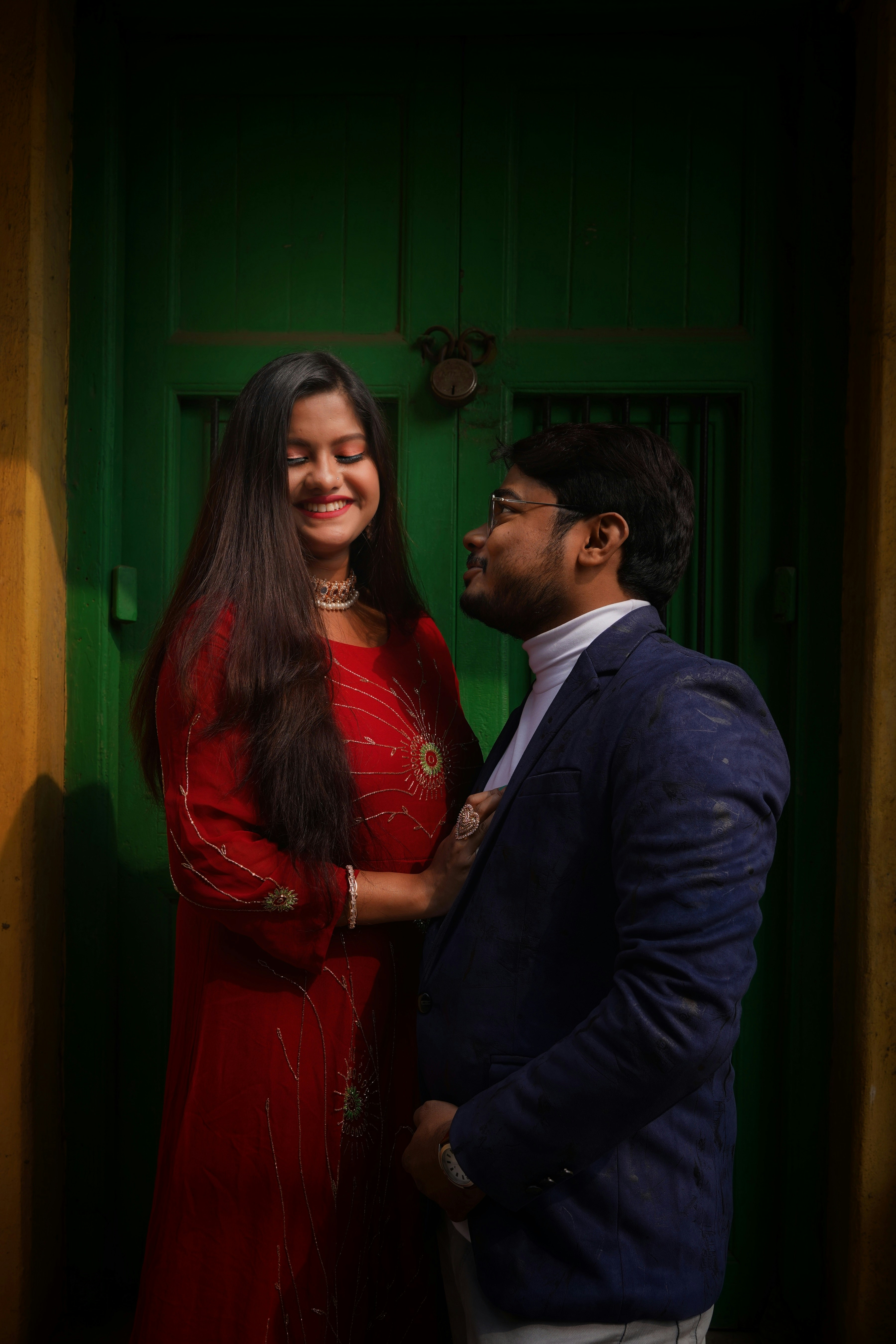 a man standing next to a woman in a red dress
