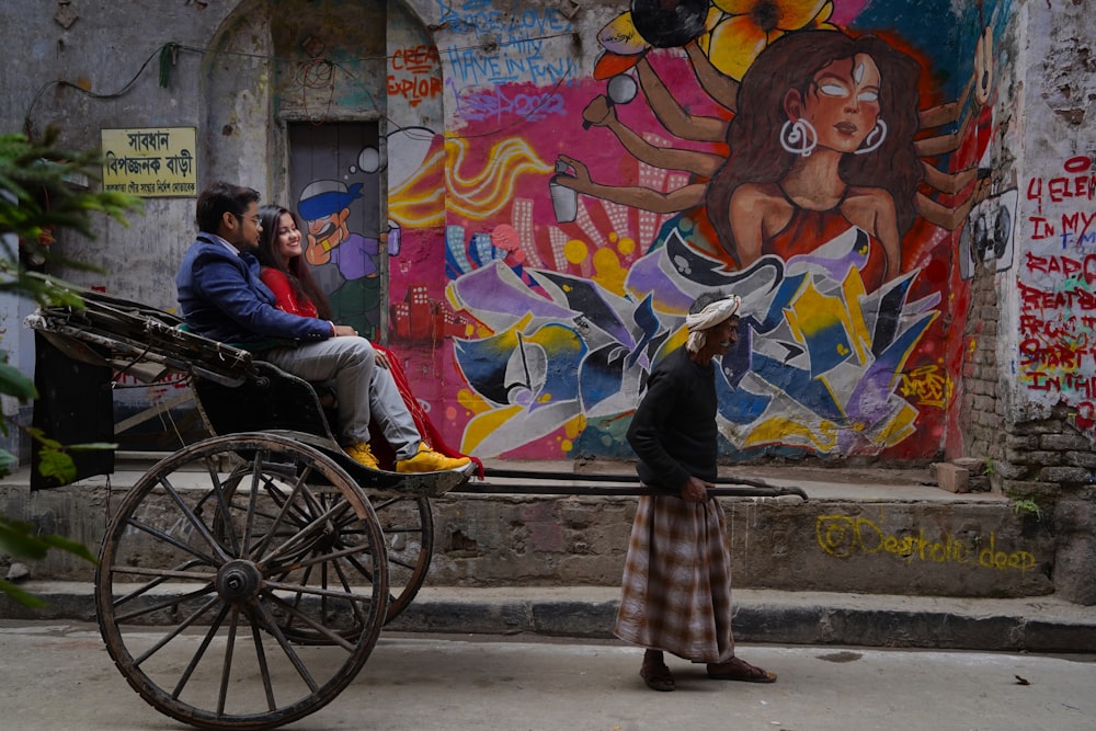 a man and a woman riding in a horse drawn carriage