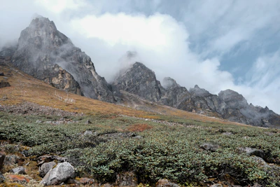 a mountain range with a few clouds in the sky