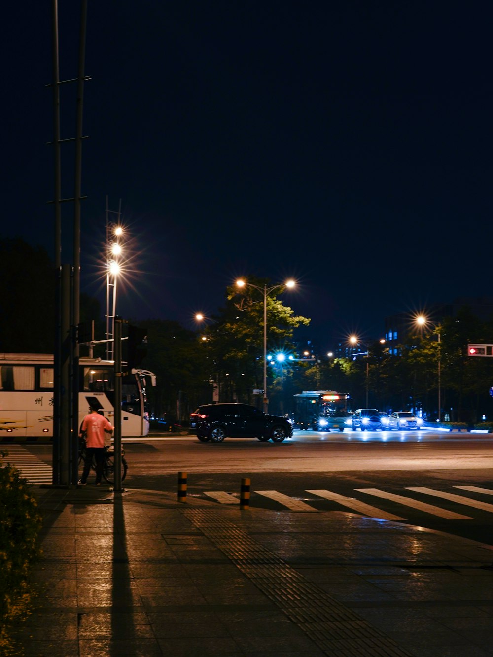 a man standing on a street corner at night