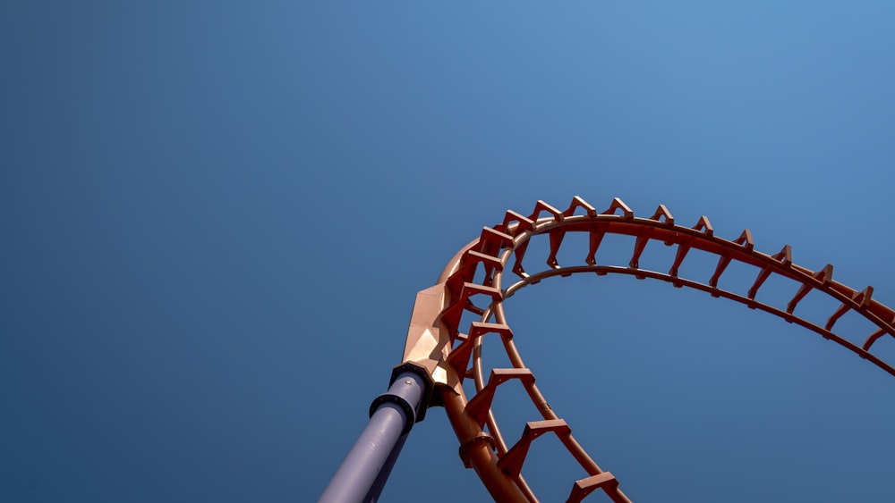 a close up of a roller coaster against a blue sky