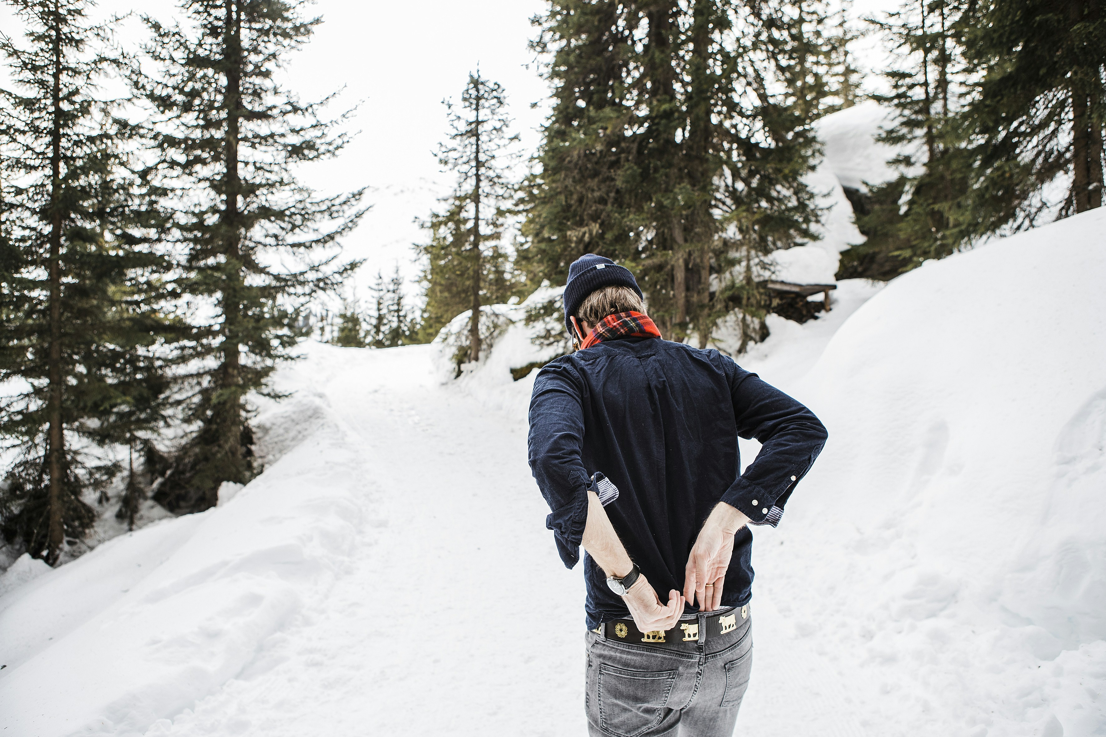a man riding a snowboard down a snow covered slope