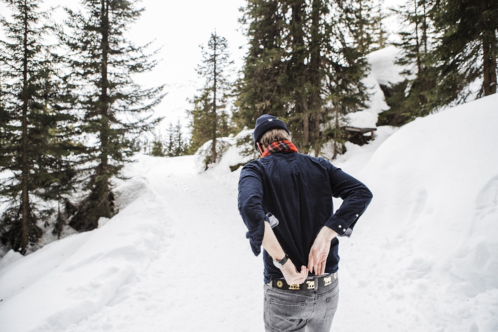 a man riding a snowboard down a snow covered slope